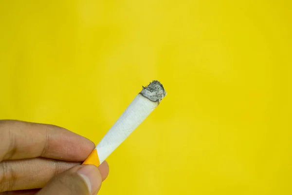 Eine Hand Hält Eine Handgemachte Zigarette Auf Gelbem Hintergrund — Stockfoto