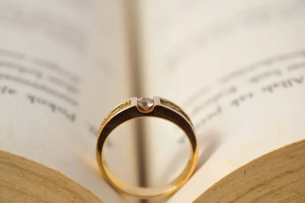 Close up golden ring with diamond between book opened