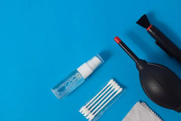 Cleaning set for camera air blower, microfiber, brush and more. Isolated on blue background