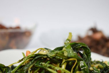 Kızarmış ıspanağı beyaz tabakta izole edilmiş beyaz arka planda kapat