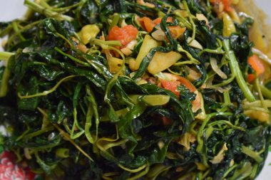 Kızarmış ıspanağı beyaz tabakta izole edilmiş beyaz arka planda kapat