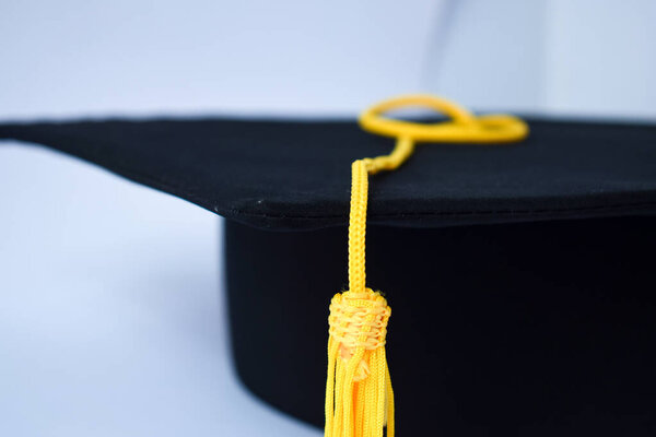Close-up Black Graduation Hat and Yellow Tassel isolated on white background