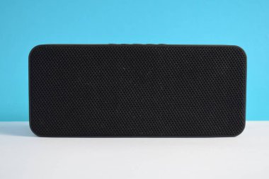 Mavi arkaplanda müzik çalmak için kablosuz siyah hoparlör kutusu, kablosuz müzik çalar, elektronik.