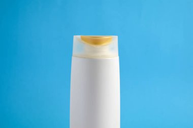 Beyaz şampuan boş. Mavi arka planlı, güzellik sigortası maketi şişesi..