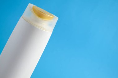 Beyaz şampuan boş. Mavi arka planlı, güzellik sigortası maketi şişesi..