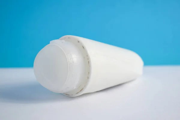 White bottle deodorant blank for mock up on blue background, product mock up, armpit health care, body care