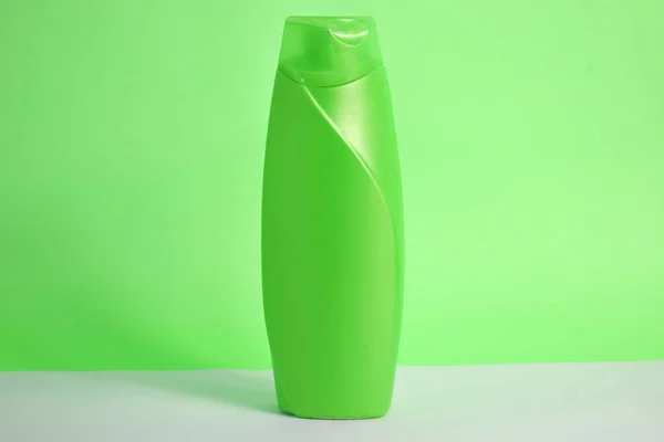 Green blank bottle shampoo minimalist bakcground, hair care bottle mock up product.