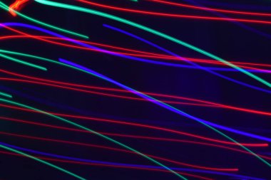 Siyah üzerine izole edilmiş uzun soluklu soyut çizgiler. Siyah arkaplanda kurşun şerit ışıklandırmasından kıvrımlı çizgiler 