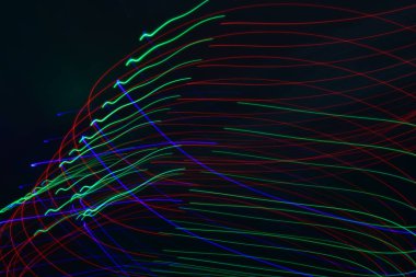 Siyah üzerine izole edilmiş uzun soluklu soyut çizgiler. Siyah arkaplanda kurşun şerit ışıklandırmasından kıvrımlı çizgiler 