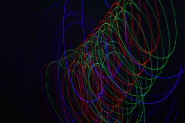 Siyah üzerine izole edilmiş uzun soluklu soyut çizgiler. Siyah arkaplanda kurşun şerit ışıklandırmasından kıvrımlı çizgiler 