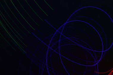 Siyah üzerine izole edilmiş uzun soluklu soyut çizgiler. Siyah arkaplanda kurşun şerit ışıklandırmasından kıvrımlı çizgiler 