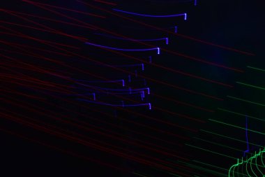 Siyah üzerine izole edilmiş uzun soluklu soyut çizgiler. Siyah arkaplanda kurşun şerit ışıklandırmasından kıvrımlı çizgiler 