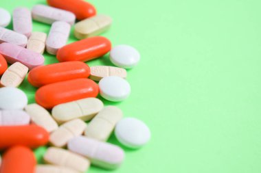Fotokopi alanı, takviye maddesi, vitamin, renkli yeşil arka planda renkli tıbbi haplar.