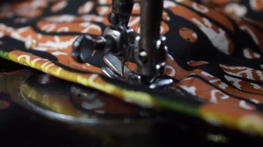 Kıdemli kadın terziyi kapatın. Batik Endonezya kumaşını kumaşa, terziye, elbiseye, dikiş makinesine, yaşlı konseptine çevirin.