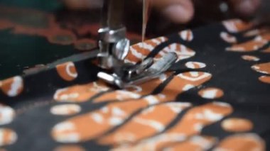 Kıdemli kadın terziyi kapatın. Batik Endonezya kumaşını kumaşa, terziye, elbiseye, dikiş makinesine, yaşlı konseptine çevirin.