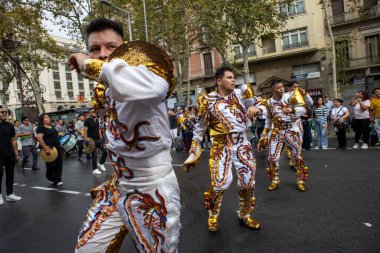 Barselona, İspanya - 12 Ekim 2024. Geleneksel kostüm ve şapkalarını giyen büyük bir erkek dansçı grubunun yakın çekim görüntüleri..