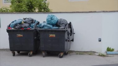 Duvarın yanında aşırı dolu iki çöp kutusu. Yüksek kalite 4k görüntü