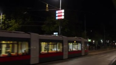 Viyana Rathaus belediye binası ve gece tramvayı geçiyor. Yüksek kalite 4k görüntü