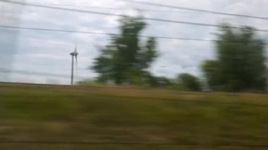 Rüzgâr değirmenleri yüksek hızlı trenden izleniyor. Yüksek kalite 4k görüntü