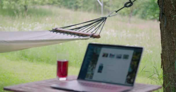 ハンモックと一緒に夏の庭にある美しいホームオフィスのセットアップ 高品質4K映像 — ストック動画
