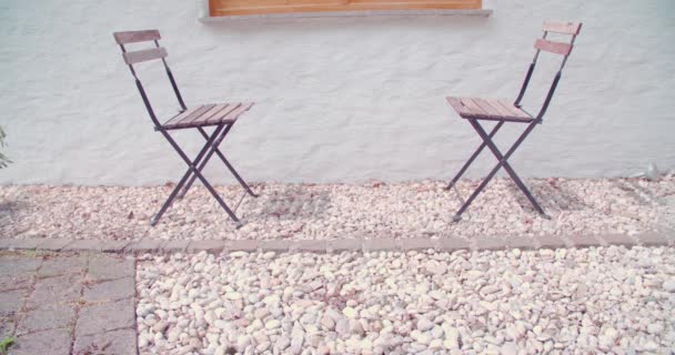 Zwei Einander Gegenüberliegende Gartenstühle Auf Der Steinterrasse Hochwertiges Filmmaterial — Stockvideo