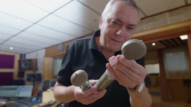오디오 엔지니어가 빈티지 마이크를 검사하고 있습니다 고품질 — 비디오
