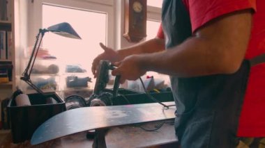 Snowboard servis teknisyeni atölyede tamirat yapıyor. Yüksek kalite 4k görüntü