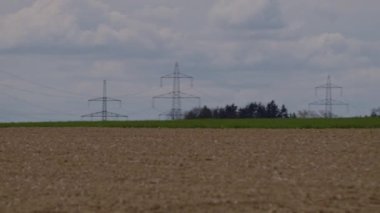 Avusturya kırsalındaki yüksek voltajlı elektrik hatlarının tele çekimi. Yüksek kalite 4k görüntü