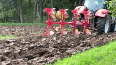 Tarım tarlasında traktörün ağır çekimde ilerlemesi. Yüksek kaliteli FullHD görüntüler