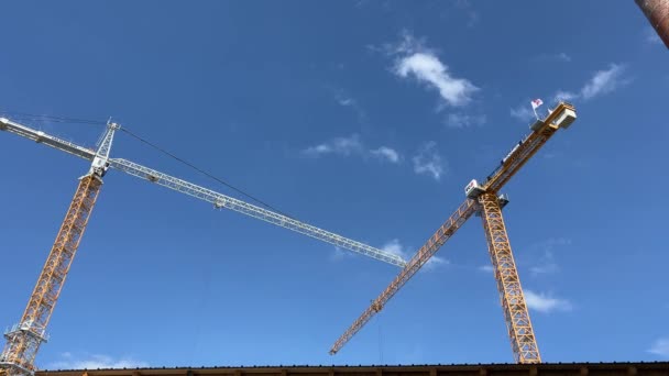 Dois Guindastes Construção Contra Céu Azul Imagens Alta Qualidade — Vídeo de Stock
