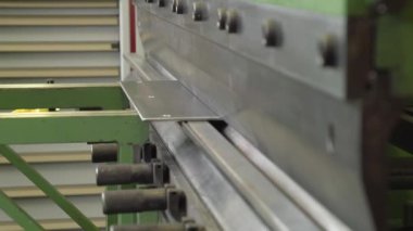 Çırak çeliği makineyle büküyor.