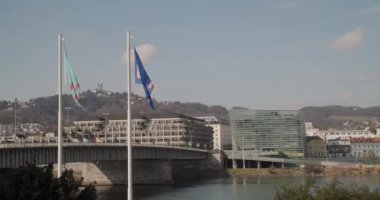 Linz şehrinin bayrakları Tuna Nehri 'nde tarihi binalarla sallanıyor. Yüksek kalite 4k görüntü