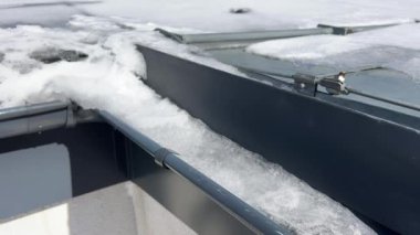 Buz saçakları ve çatı oluğunda eriyen karlar. Yüksek kalite 4k görüntü