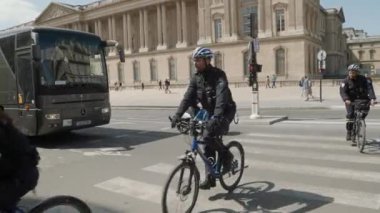 Fransa, Paris 'teki Louvre Sarayı' nda bisikletli polis. Yüksek kalite 4k görüntü