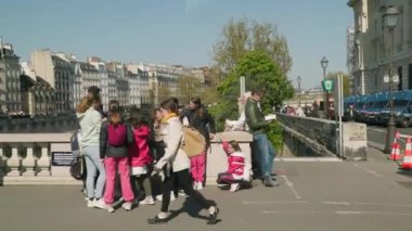 Paris, Fransa 'daki Seine nehri köprüsünde yürüyen yayalar. Yüksek kalite 4k görüntü