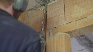 Çarpışma matkabıyla beton tavanı delen bir inşaat işçisi. Yüksek kalite 4k görüntü