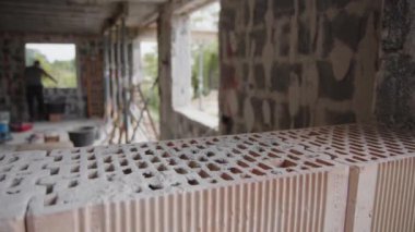 İnşaat alanında ön planda tuğlayla çalışan inşaatçılar. Yüksek kalite 4k görüntü