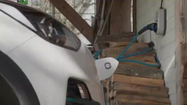 Elektrikli araba takıldı ve garaj kapısında şarj ediliyor. Yüksek kalite 4k görüntü
