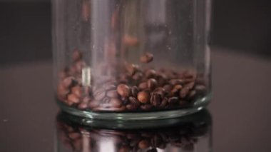 Kahve çekirdekleri yavaş çekimde bardağa dökülüyor. Yüksek kalite 4k görüntü
