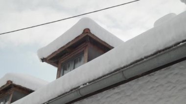 Kışın karla kaplı yurtlar ve kırsal evlerin çatısı. Yüksek kalite 4k görüntü
