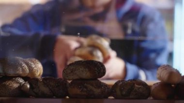 İşçi rafa haşhaş tohumlu hamur işleri koyuyor. Yüksek kalite 4k görüntü