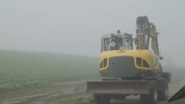 Kazıcı kırsal yolda buldozerle ilerliyor. Yüksek kalite 4k görüntü