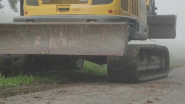 Kazıcı kırsal yolda buldozerle ilerliyor. Yüksek kalite 4k görüntü