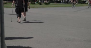 Devlet bahçesinde koltuk değnekleriyle yürüyen son sınıf öğrencisi. Yüksek kalite 4k görüntü