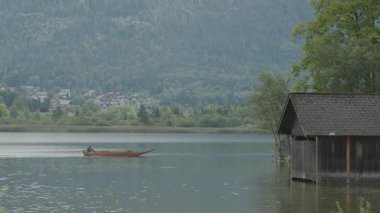 Geleneksel balıkçı teknesi Salzkammergut 'taki Hallstatt Gölü' nde geziyor. Yüksek kalite 4k görüntü
