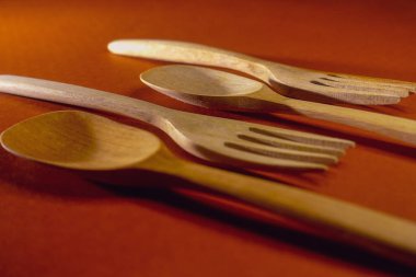 Ahşap kaşık ve çatal kırmızı arka planda izole, stüdyo çekimi gündüz vakti.