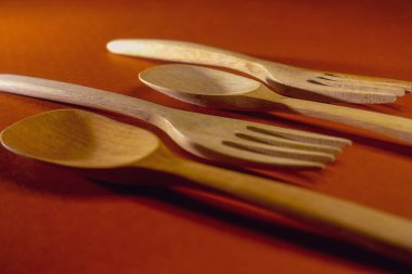 Ahşap kaşık ve çatalın yakın plan fotoğrafı. Kırmızı arka planda, kapalı stüdyo çekimlerinde izole edilmiş. Gün içinde.. 