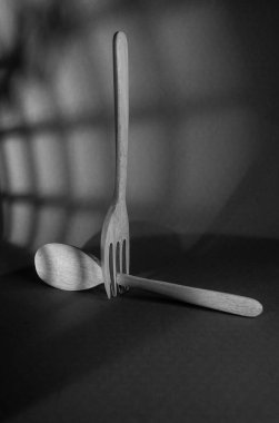 Tahta kaşık ve çatal pencerenin gölgesinde izole edilmiş..