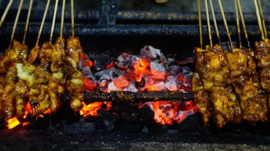 Tipik Endonezya sokak yemekleri tavuk satay, tavuk eti bambu çubuğuna eğilmiş kömürle kızartılmış ve tatlı fıstık sosuyla servis edilmiş..
