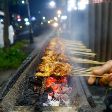 Tipik Endonezya sokak yemekleri tavuk satay, tavuk eti bambu çubuğuna eğilmiş kömürle kızartılmış ve tatlı fıstık sosuyla servis edilmiş..